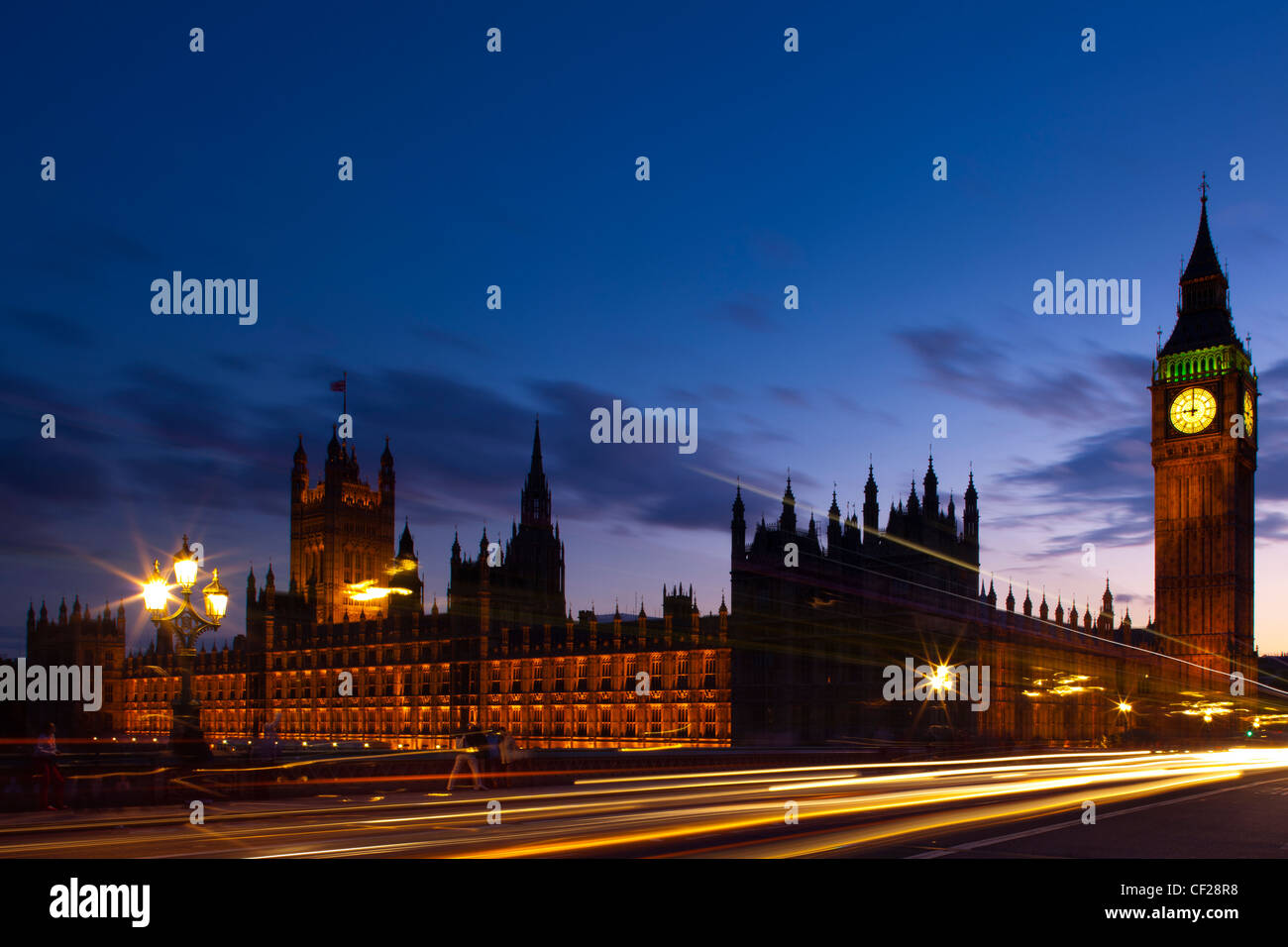 Light trails from traffic passing over Westminster Bridge with Big Ben and the Houses of Parliament in the background. Stock Photo