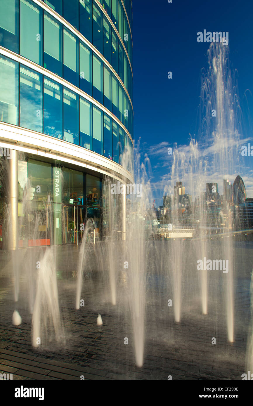 Water fountains near City Hall and the 'More London' development on the south bank of the River Thames, looking towards the land Stock Photo