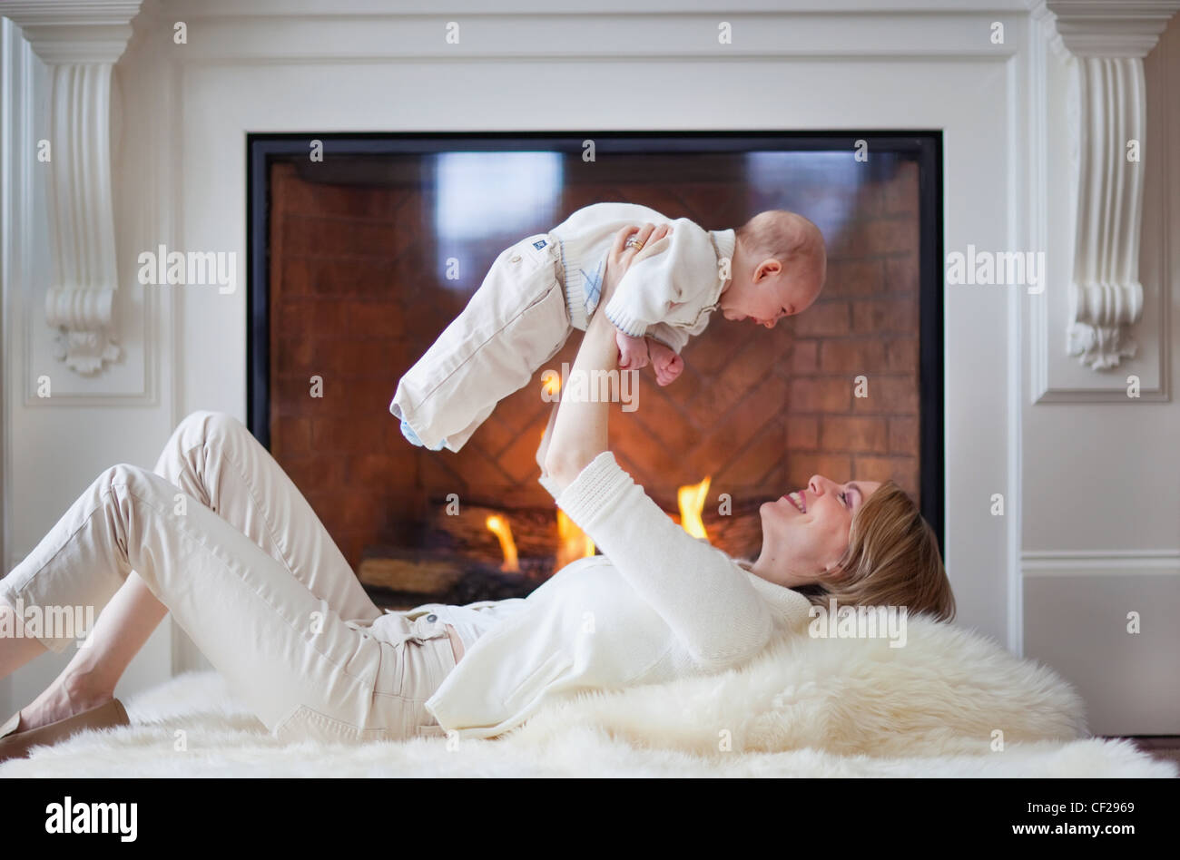 Mother And Baby On Carpet In Front Of Fireplace; Jordan Ontario Canada Stock Photo