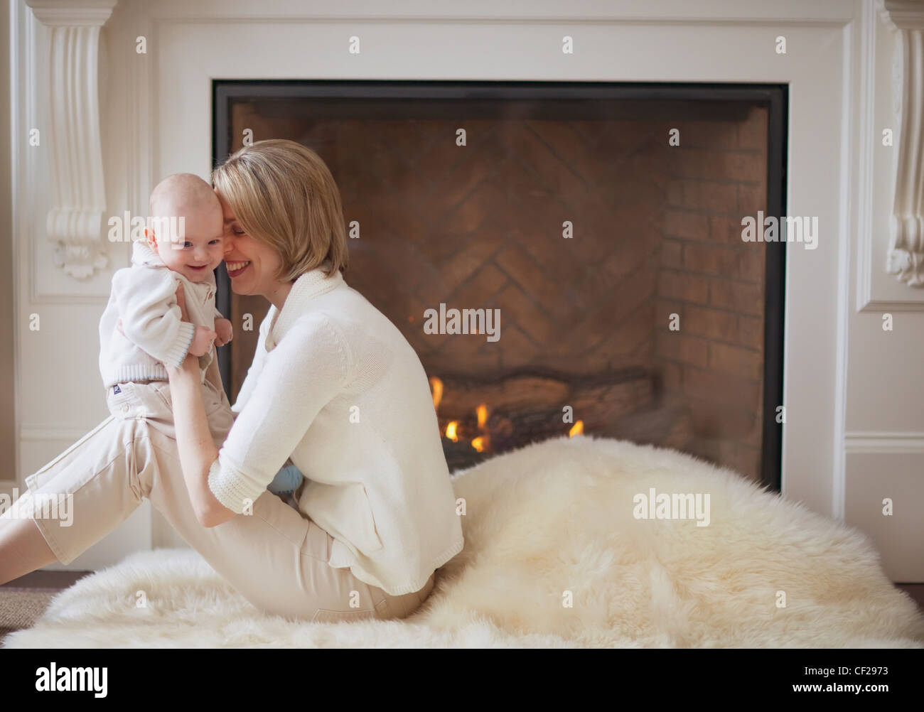 Mother And Baby Cuddling In Front Of Fireplace; Jordan Ontario Canada