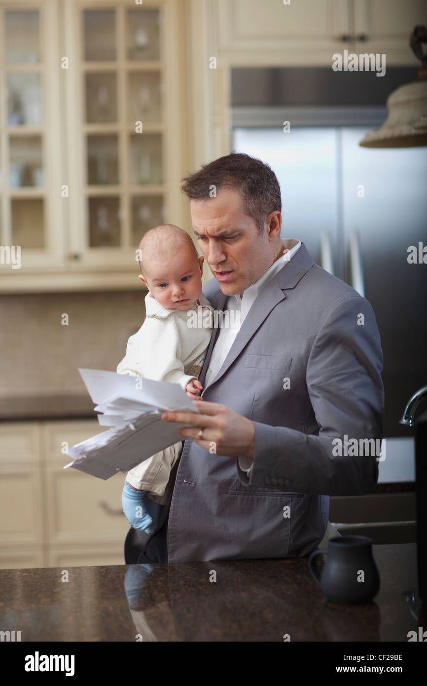 Businessman Father With Baby Stressing Over Household Bills; Jordan Ontario Canada Stock Photo
