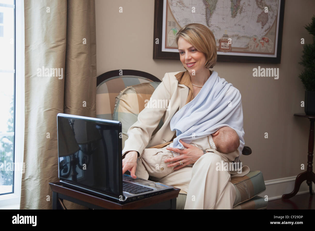 Mother Breastfeeding Baby While On Computer; Jordan Ontario Canada Stock Photo