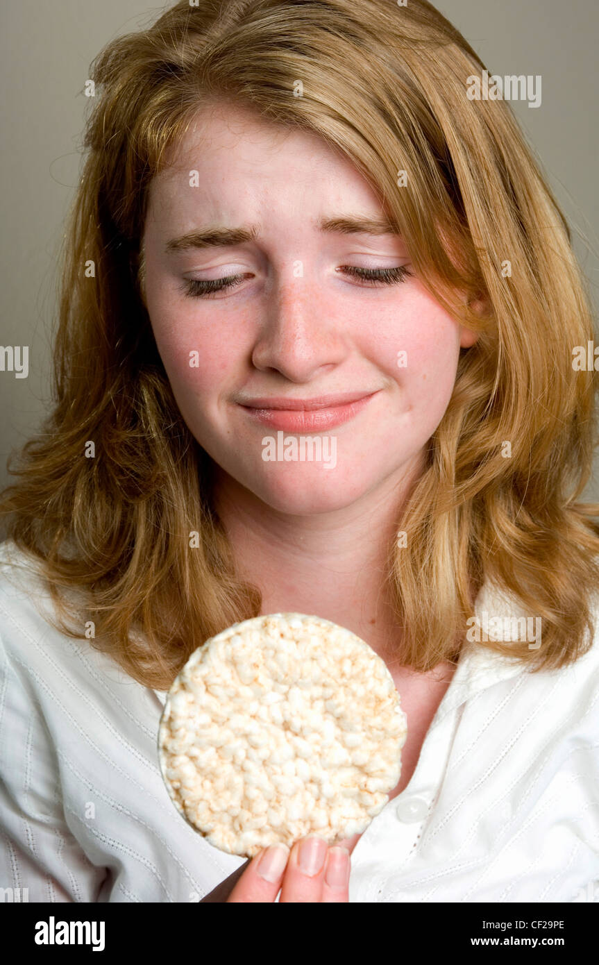 Female with a worried expressing holding a rice cake Stock Photo Alamy