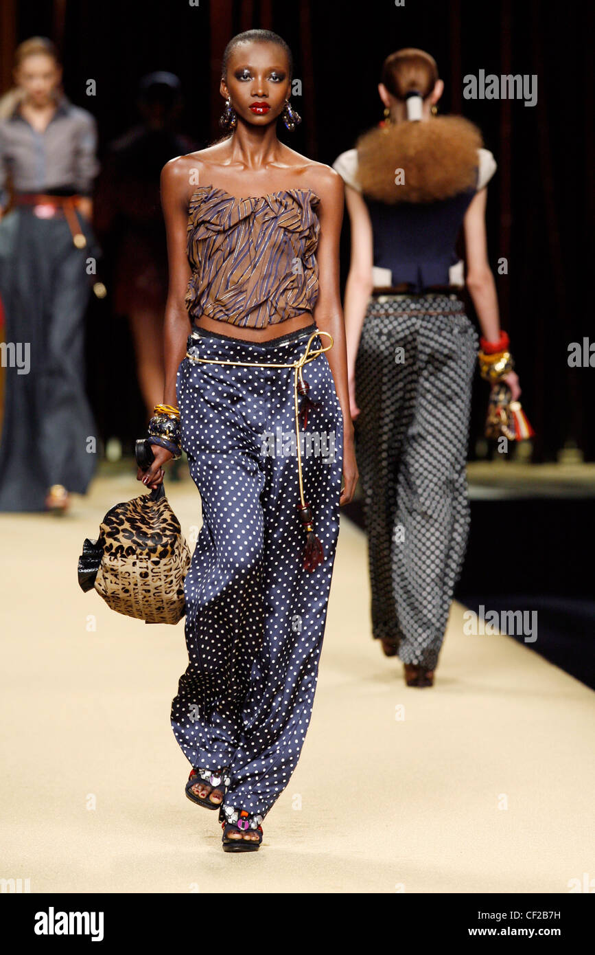 Model wearing a brown crinckled bodice purple lines, long blue polka