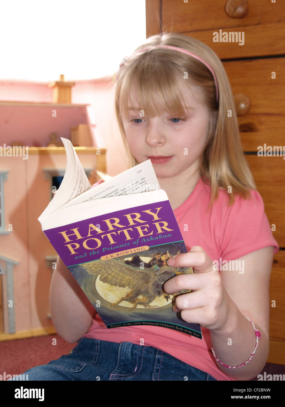Female child with blonde shoulder length hair, wearing a pink t shirt and jeans, reading a Harry Potter book Stock Photo - Alamy Female child with blonde shoulder length hair, wearing a pink t shirt and jeans, reading a Harry Potter book Stock Photo - Alamy