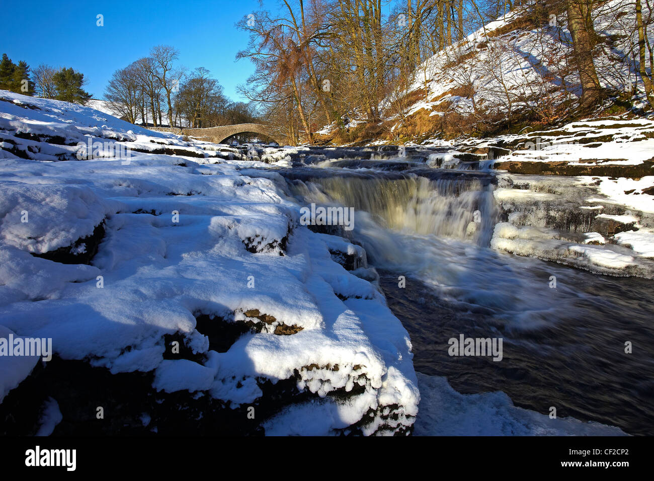 Stainforth Force, a waterfall on the River Ribble and 17th century Packhorse Bridge in winter. Stock Photo