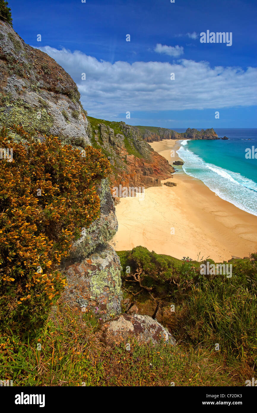 View down from the clifftop to the golden sand and turquoise sea at Pednvounder beach with Treen Cliffs and Logan Rock in the di Stock Photo