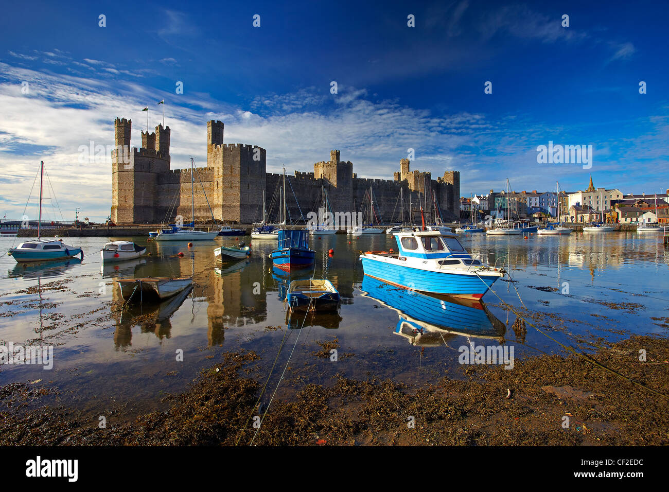 Boats moored by Caernarfon Castle at the mouth of the of the Seiont river. Stock Photo
