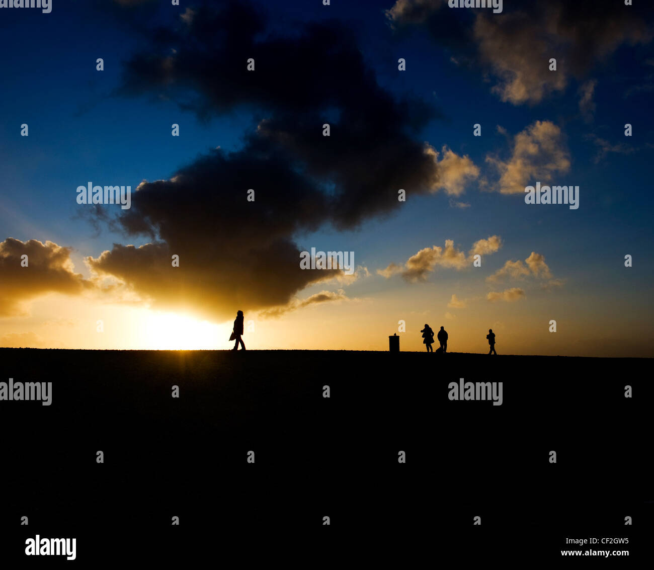 Silhouettes of people walking at sunset Stock Photo - Alamy