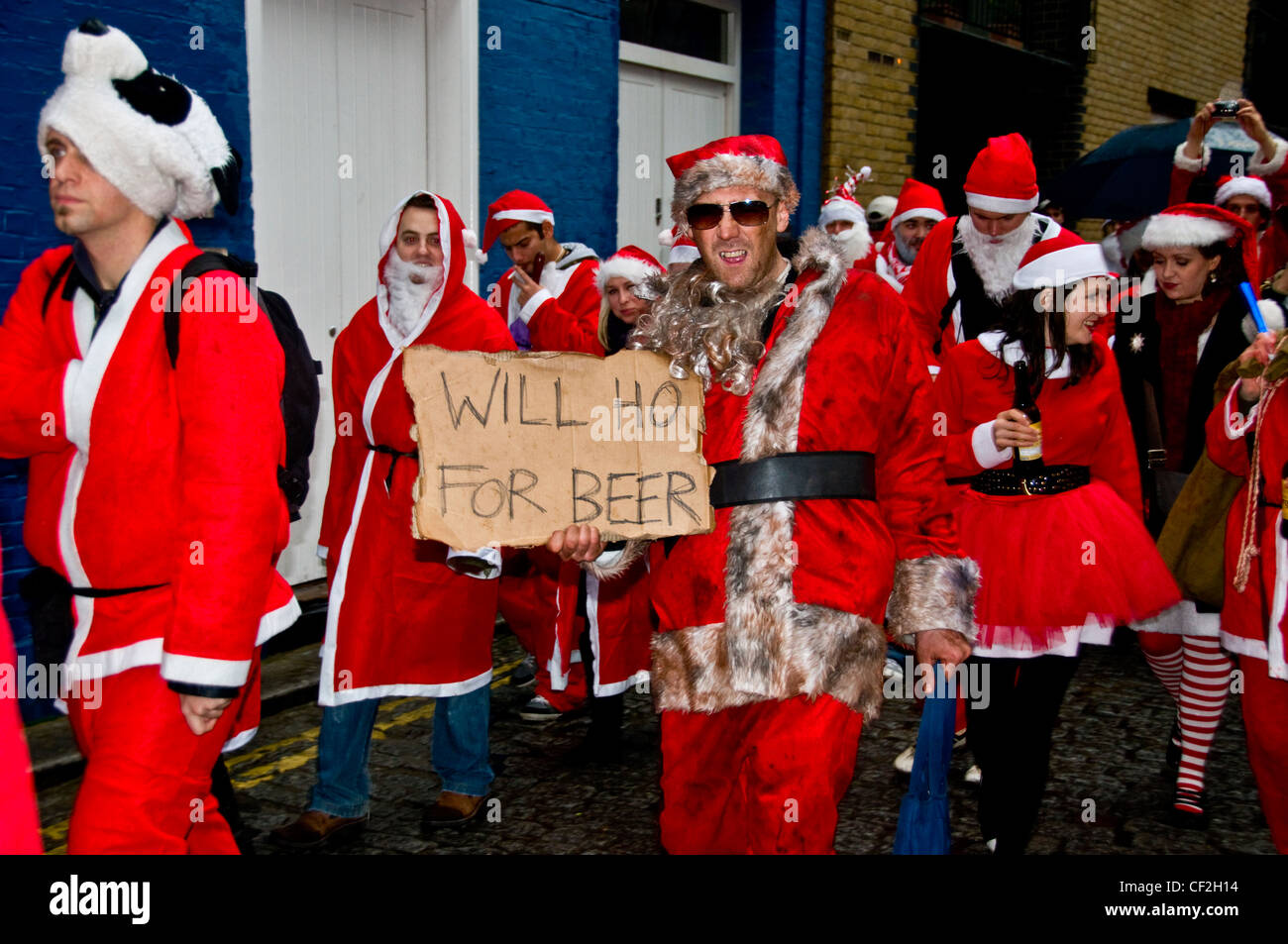 A march along the South Bank in London by people dressed as Santa Claus. Stock Photo