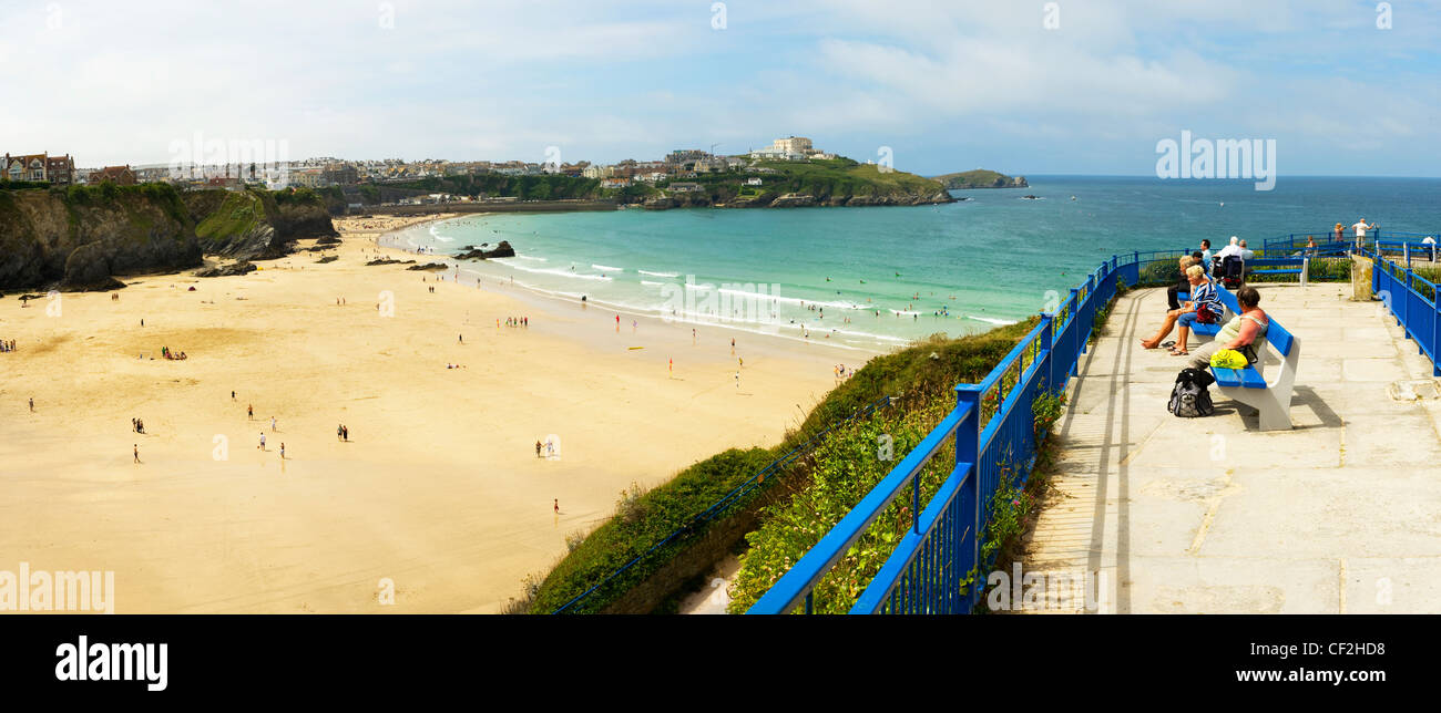 A panoramic view of holidaymakers sitting on benches overlooking Great Western Beach in Newquay. Stock Photo