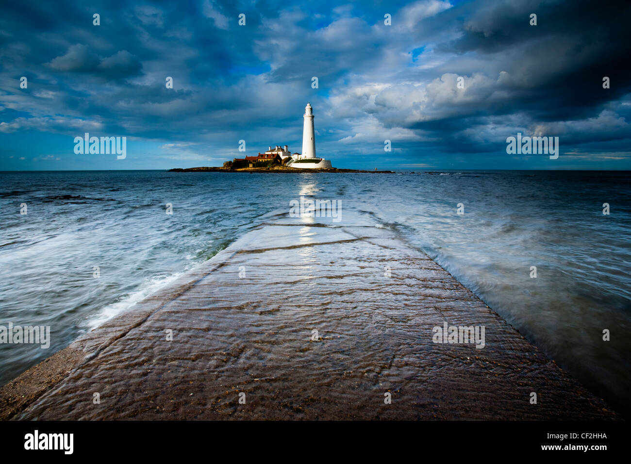 Incoming tide engulfs the causeway linking St Mary's Island & lighthouse to the mainland. Stock Photo