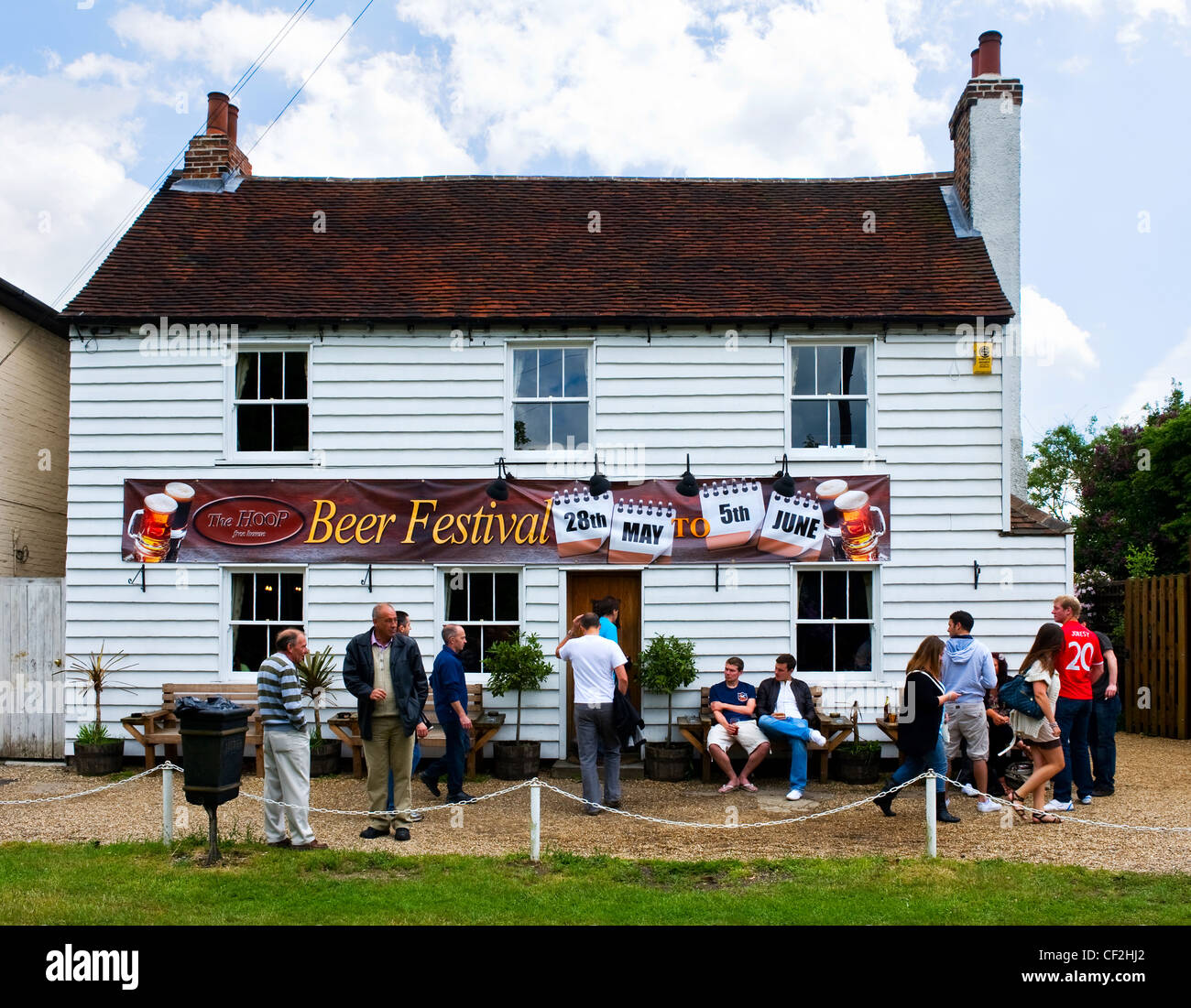 Customers socialising outside The Hoop Public House during the annual beer festival. Stock Photo