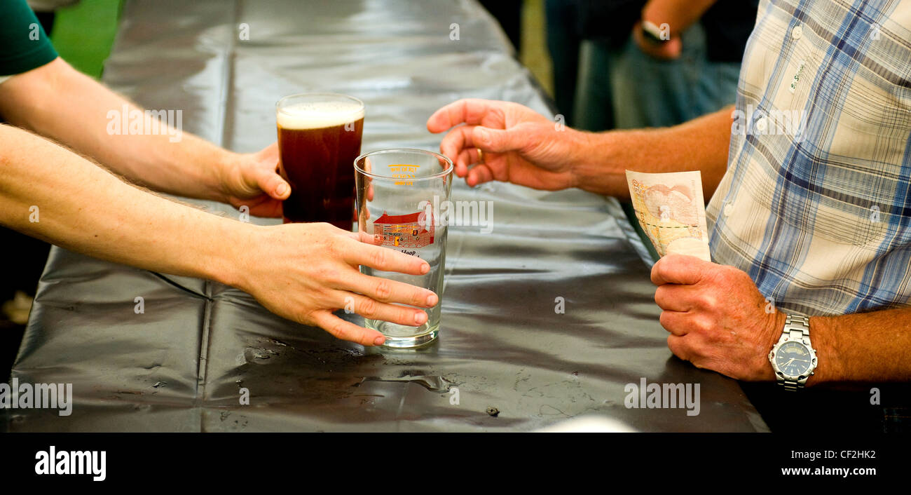 A customer buying a pint of real ale at the Hoop Beer Festival in Stock. Stock Photo