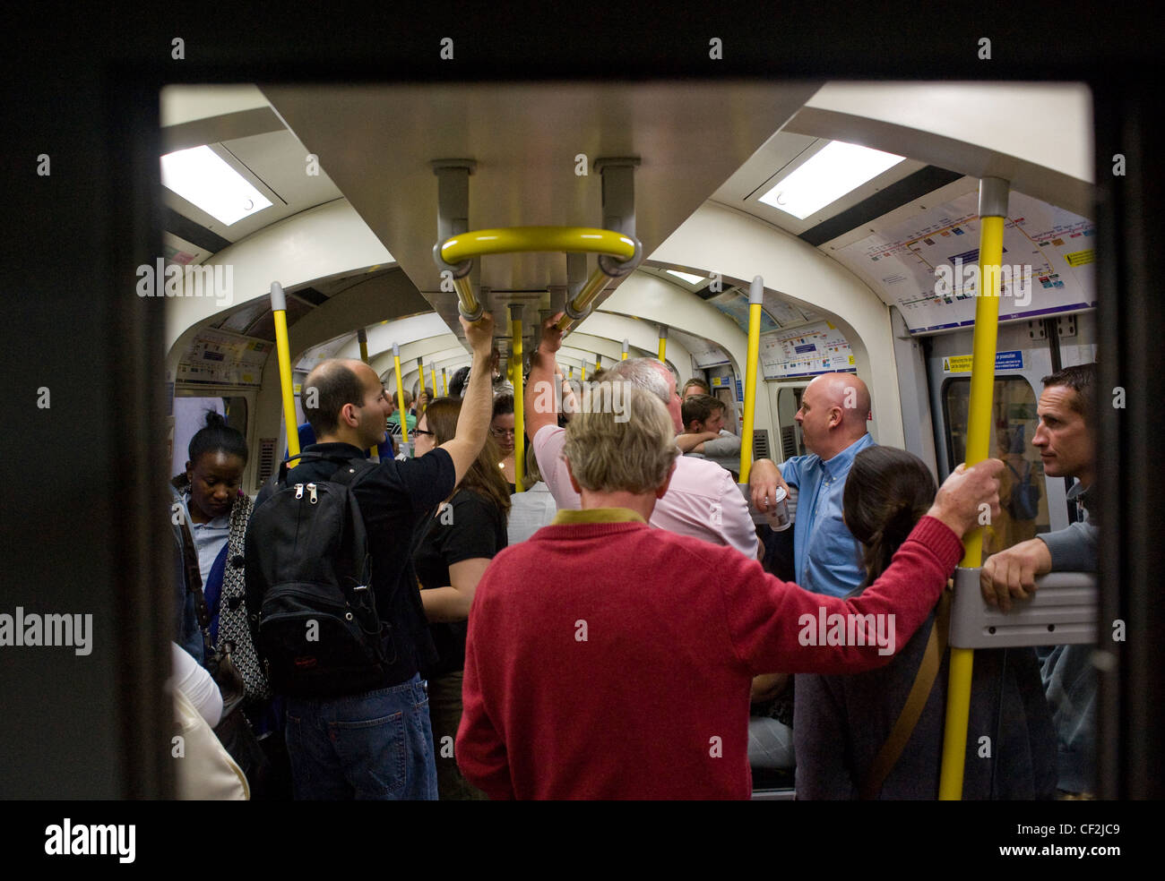 Commuters packed inside the carriage of a tube train on the London Underground. Stock Photo