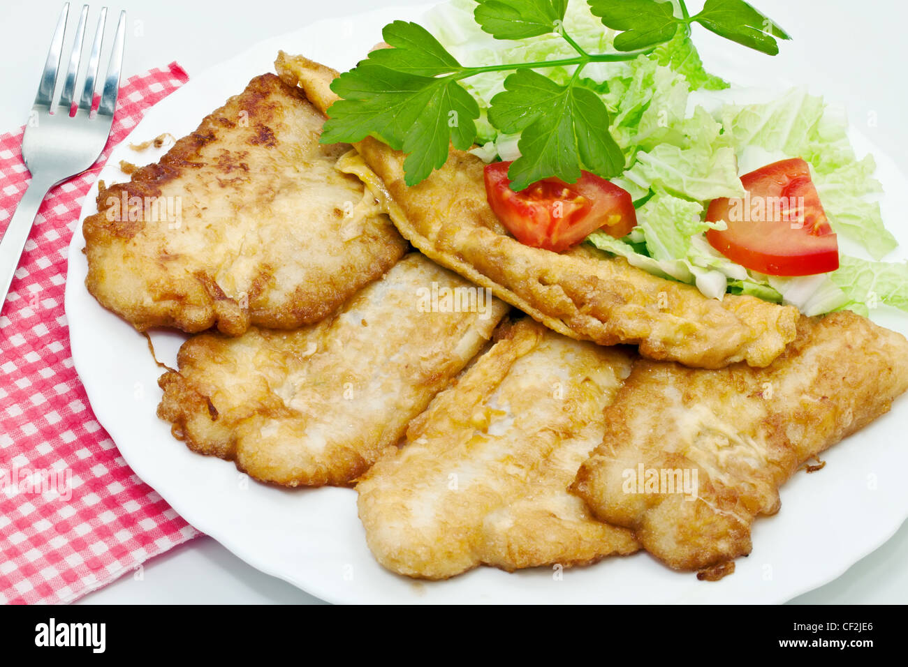 Fried fish fillets with egg and salad. Stock Photo