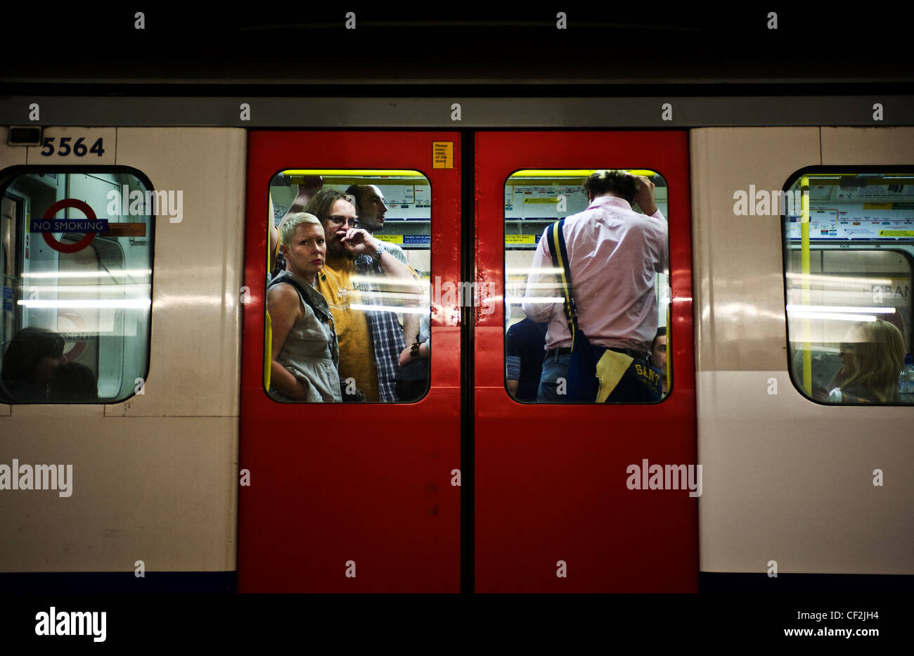 Commuters standing on board a London Underground tube train. Stock Photo