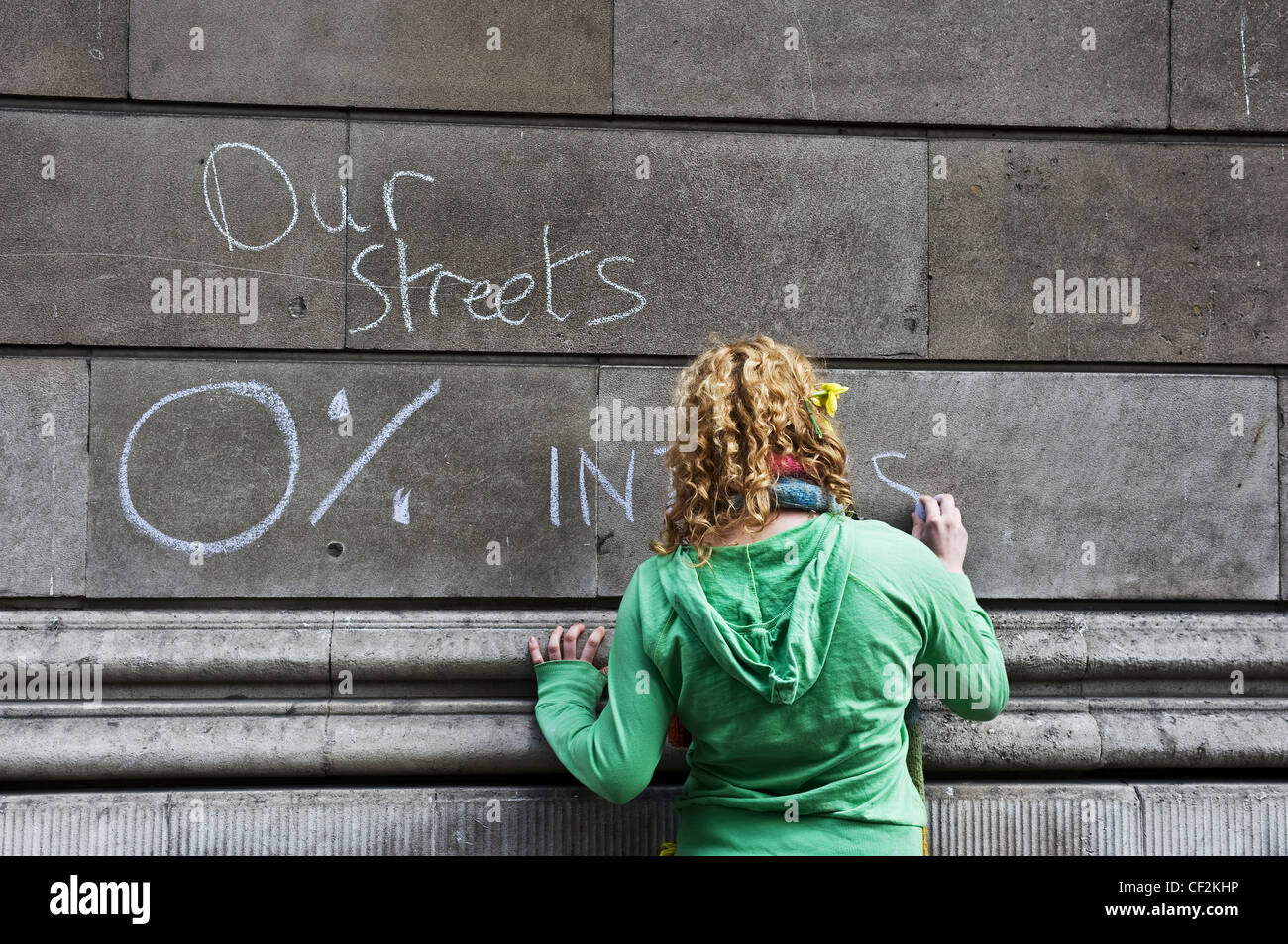 Protester scrawling graffiti on the wall of the Bank of England at the G20 demonstration in the City of London. Stock Photo