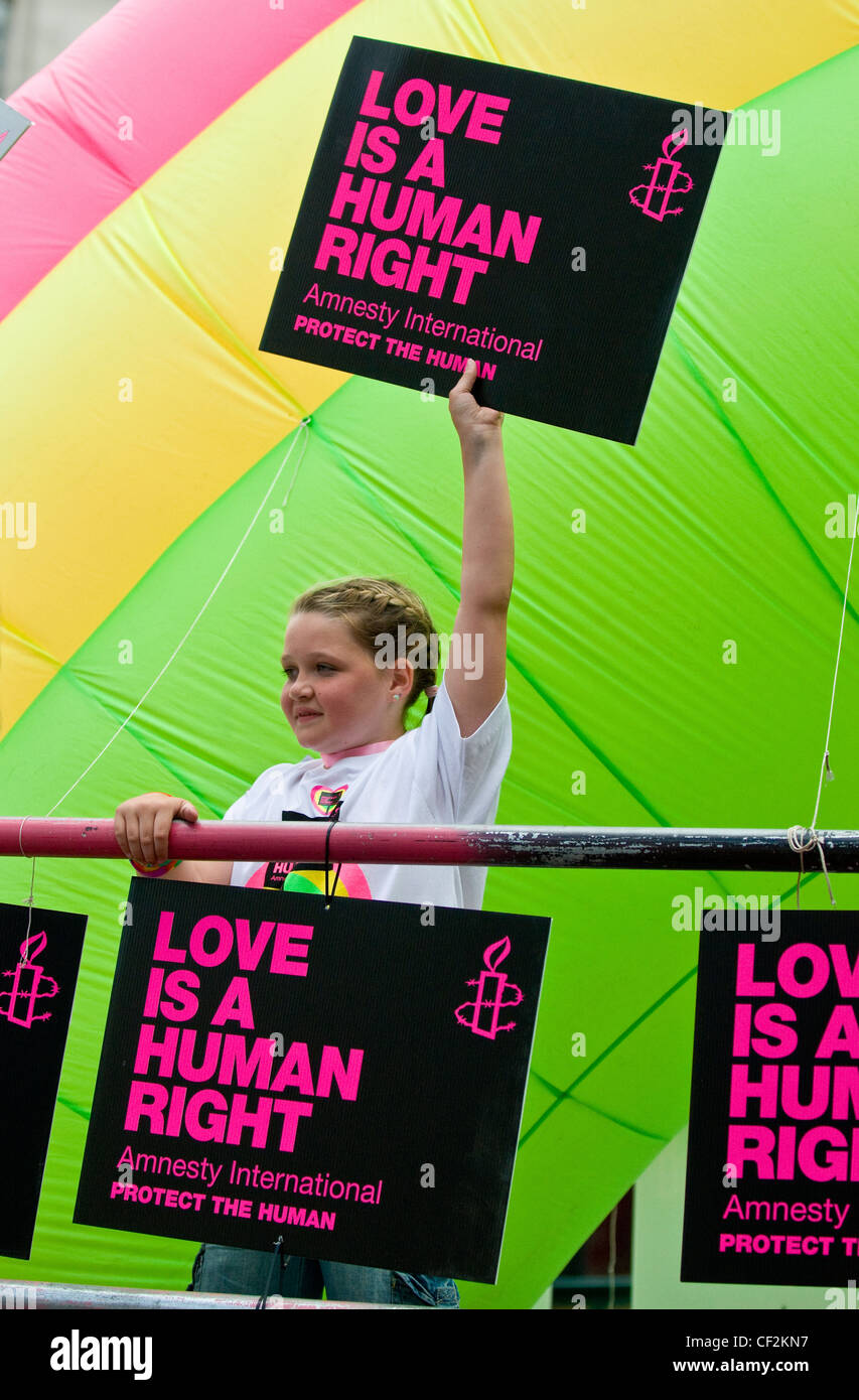 A young girl holding an Amnesty International placard stating 'Love is a Human Right' at the Pride London parade. Stock Photo