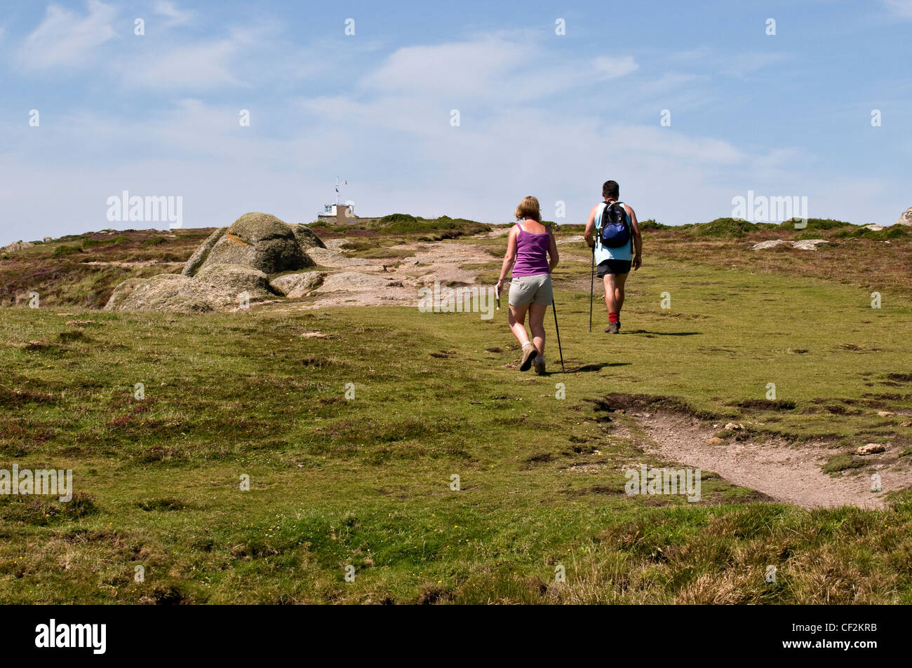 Two ramblers walking along the South West Coast Path in Cornwall. Stock Photo