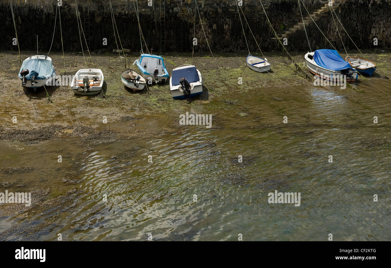 Small boats moored at low tide in Falmouth harbour. Stock Photo