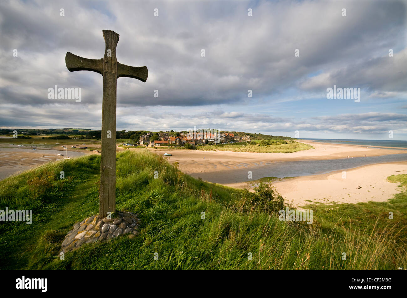 A cross on St Cuthberts Hill overlooking the small coastal town of Alnmouth on the estuary of the River Aln on the north east co Stock Photo