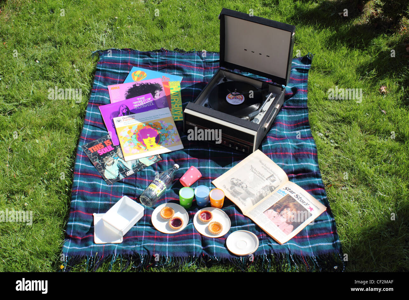 Sixties inspired picnic with LP records, record player and magazine