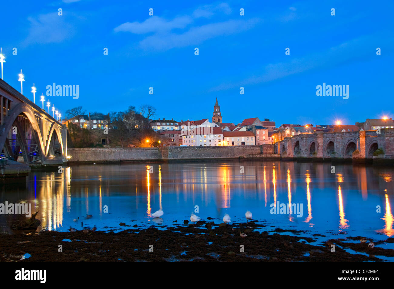 Dusk view across the River Tweed from Tweedmouth towards Berwick upon Tweed, featuring the 17th century Berwick Bridge and the R Stock Photo