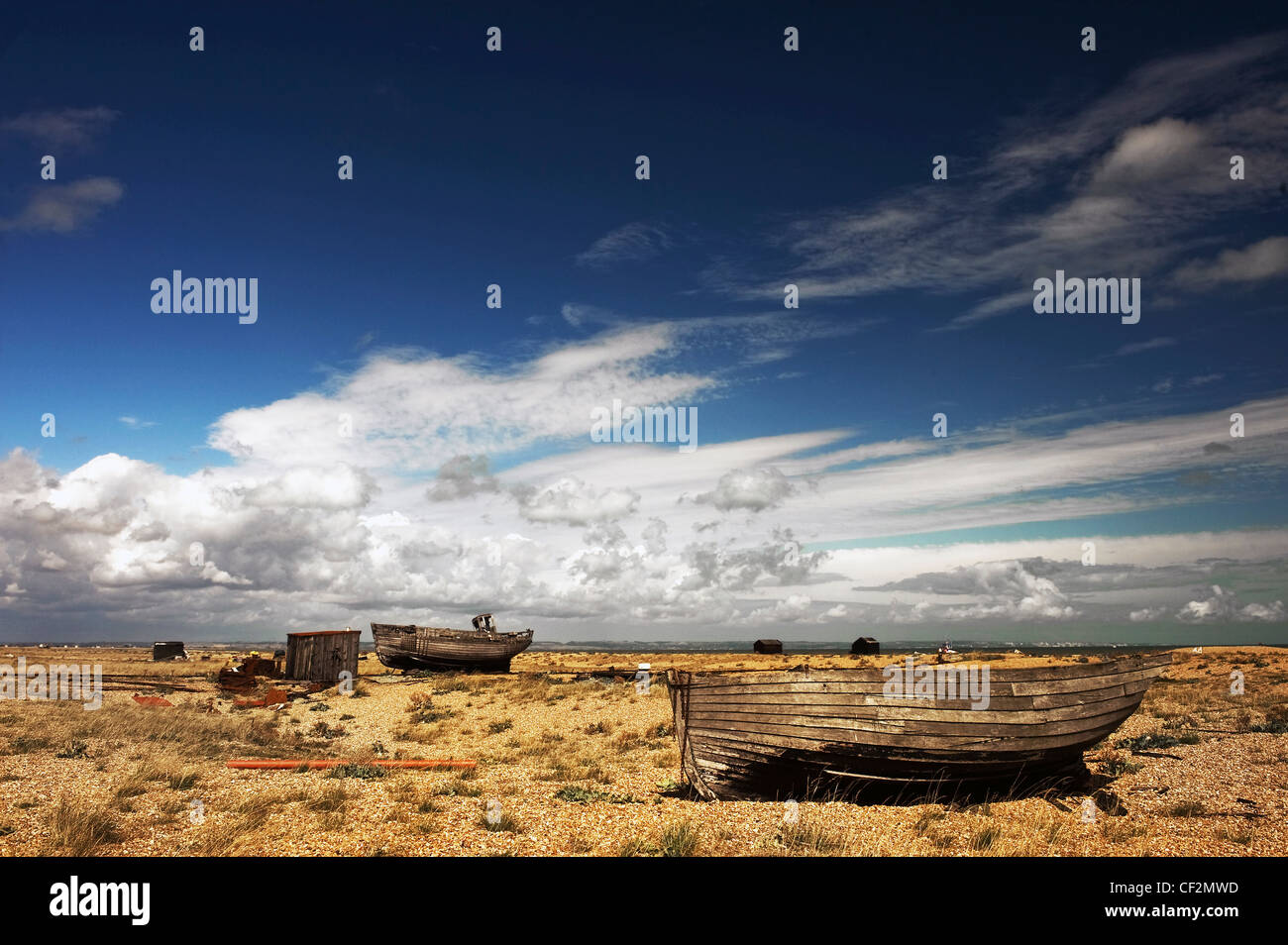 Abandoned wooden fishing boats beached on the shingle beach at ...