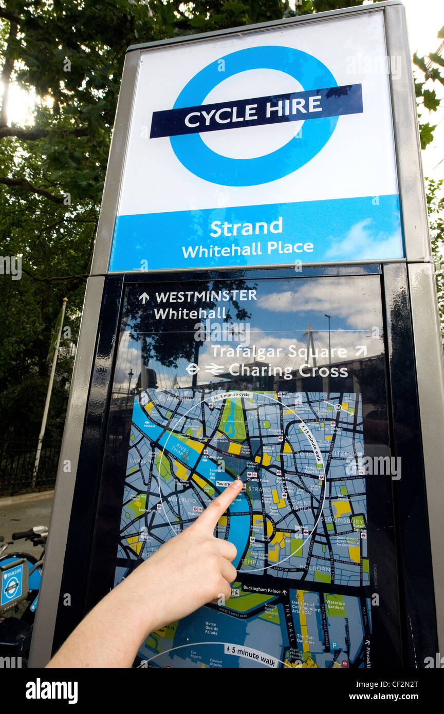 Close-up of a persons hand pointing out their location on a map at a terminal of a Barclays Cycle Hire docking station. Stock Photo