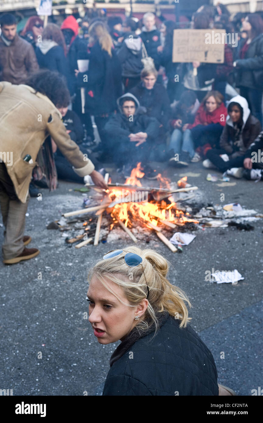 Students sitting around a bonfire in a street during a student demonstration. Stock Photo