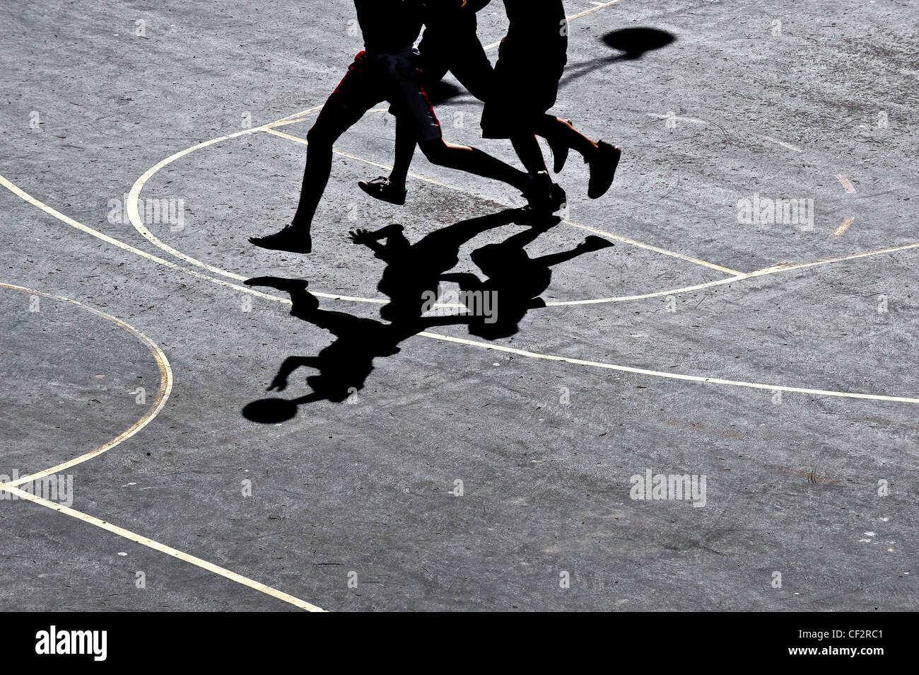 Shadows cast on a court by basketball players. Stock Photo