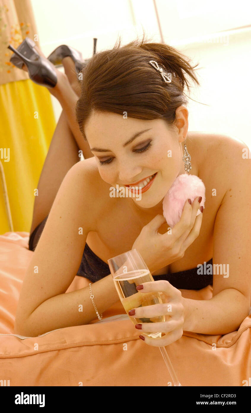 Female brunette hair up sparkly hair slide wearing black strapless dress sheer tights and black high heels, eyeliner brown Stock Photo
