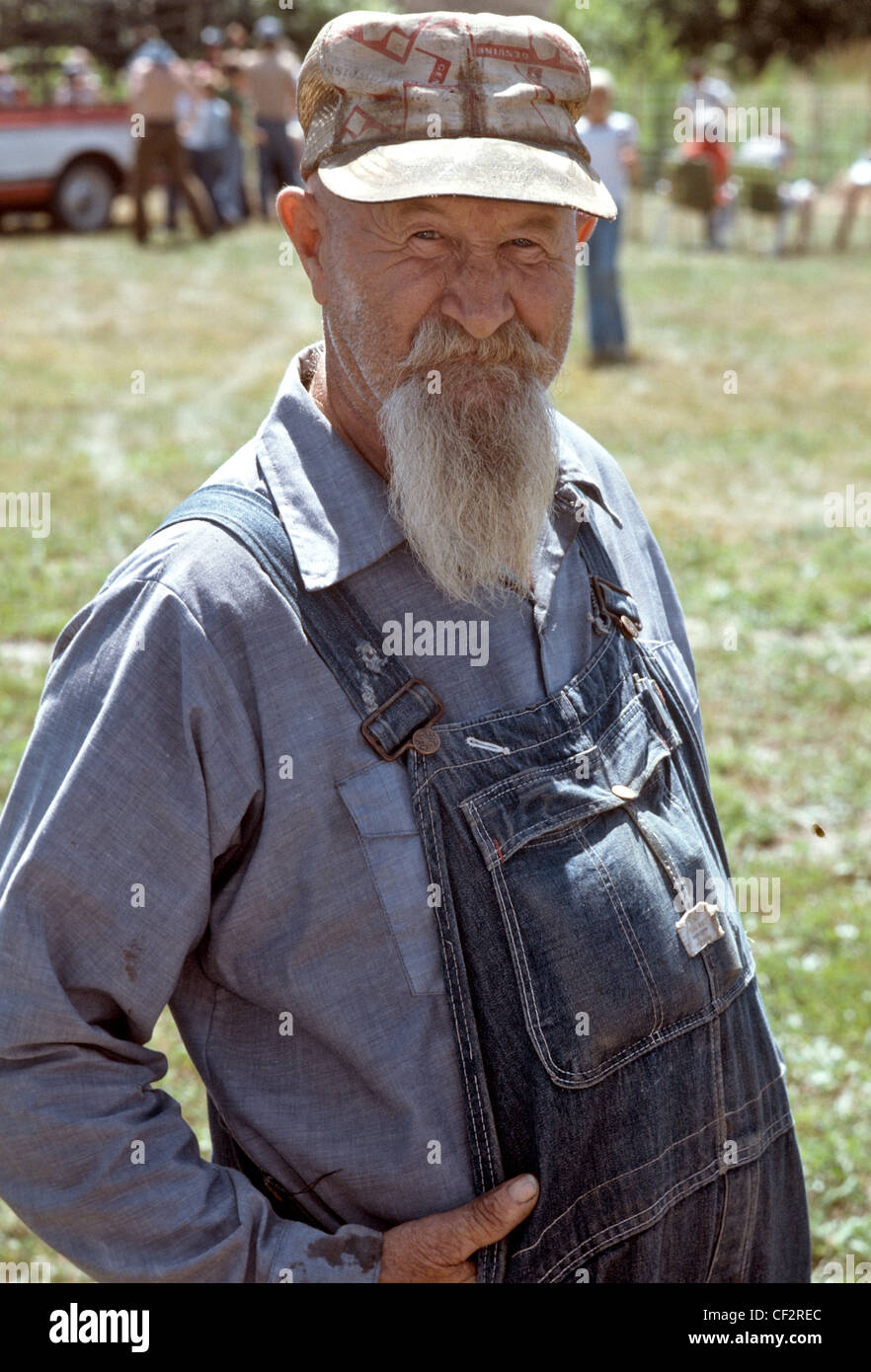 Old man with long tapered beard in cap and overalls looking to camera Stock  Photo - Alamy
