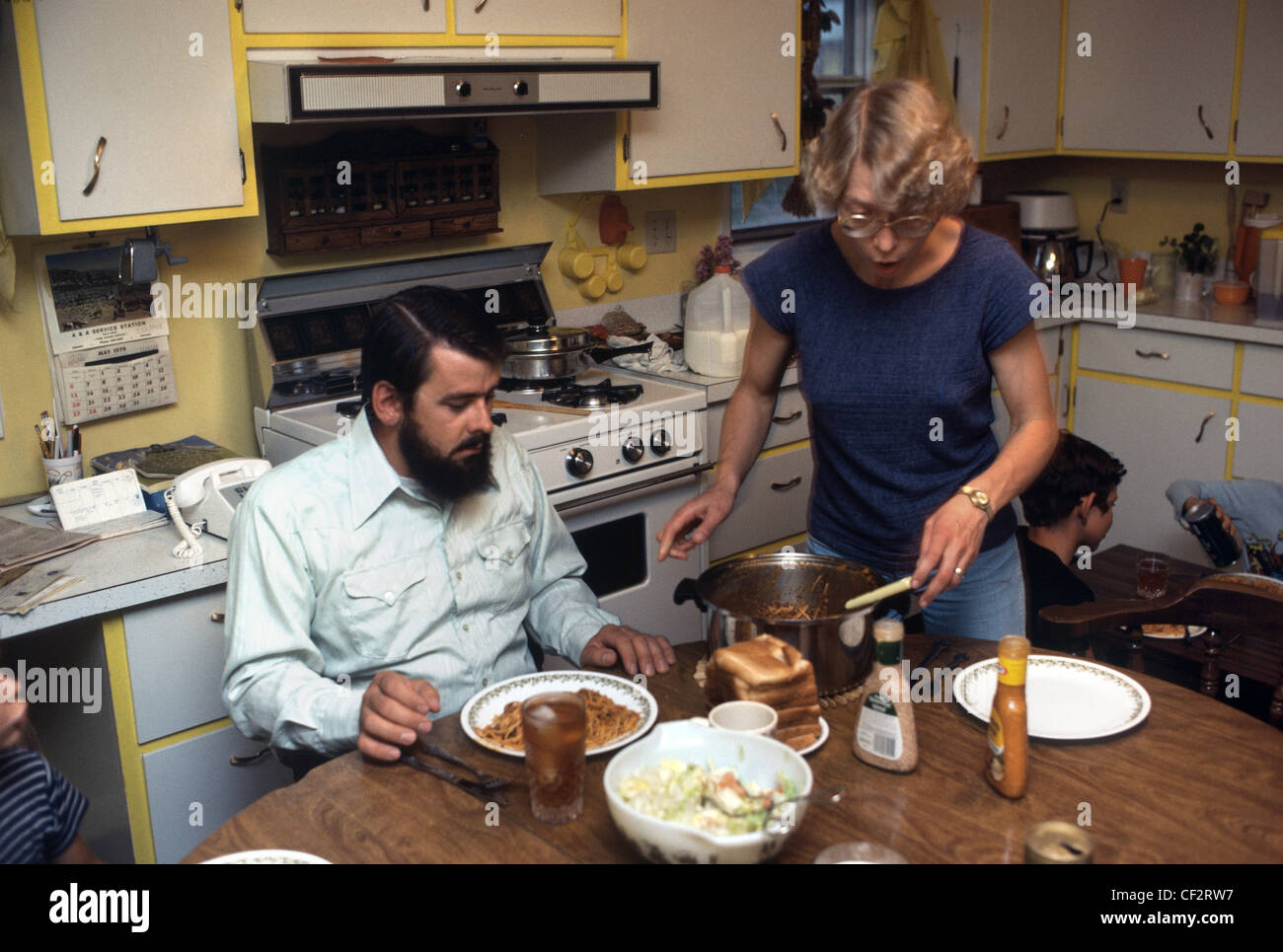Interior of a 1970's kitchen where wife serves up dinner Stock Photo