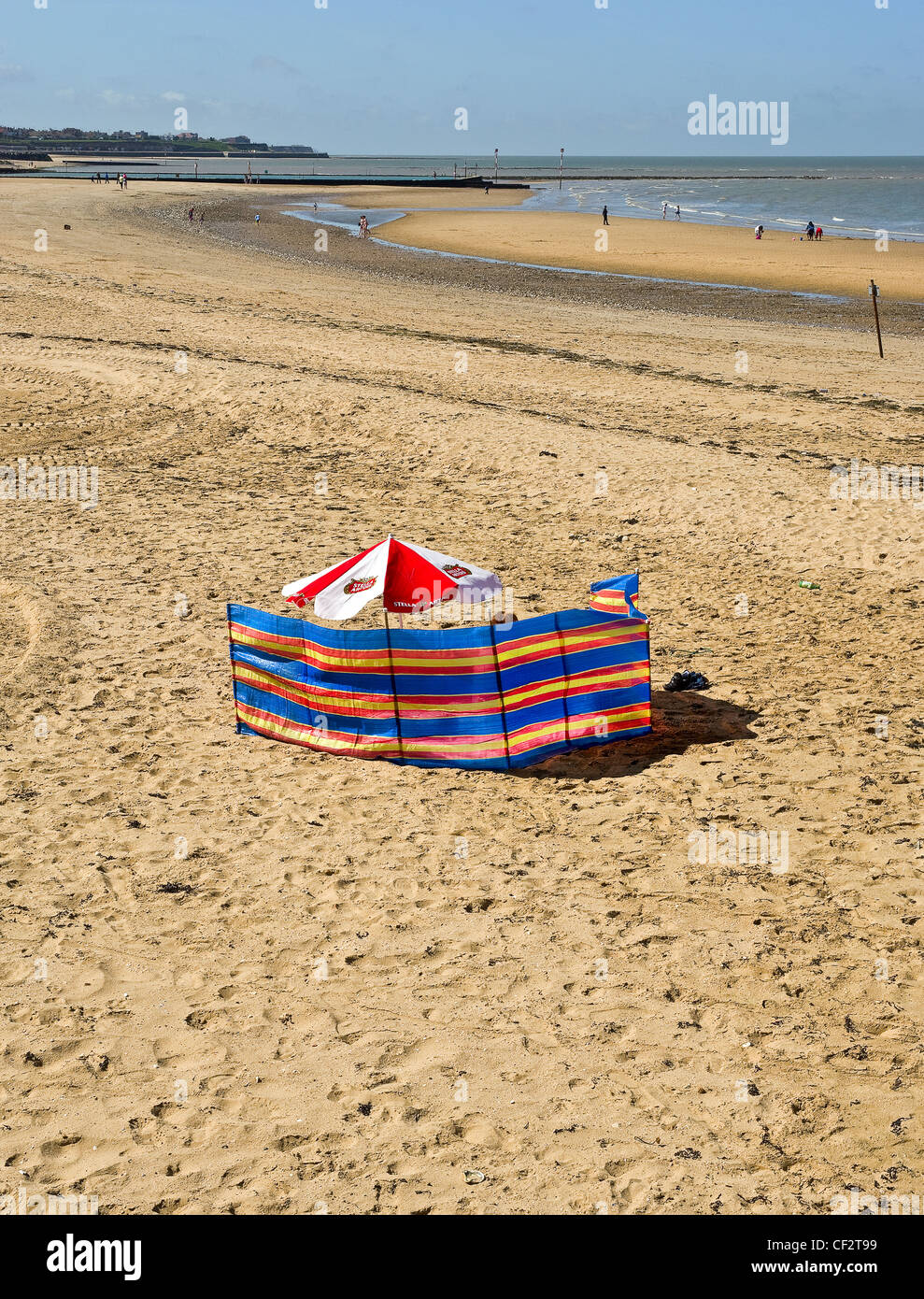 A windbreak and parasol on Margate beach. Stock Photo