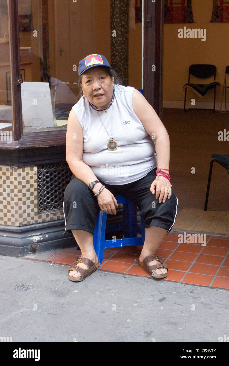 A woman from Tibet outside her Chinese medicine shop in Central London. Herbology is the Chinese art of combining medicinal herb Stock Photo