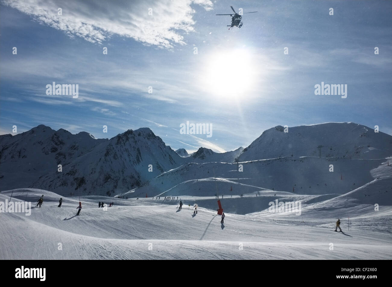 A helicopter takes off over skiers at Peyragudes ski resort, Midi-Pyrenees, France. Stock Photo