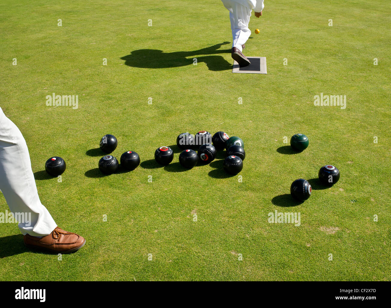 A bowler setting a mark with a jack at the start of a game of Crown Greens Bowls at Newlyn Bowling Club. Stock Photo