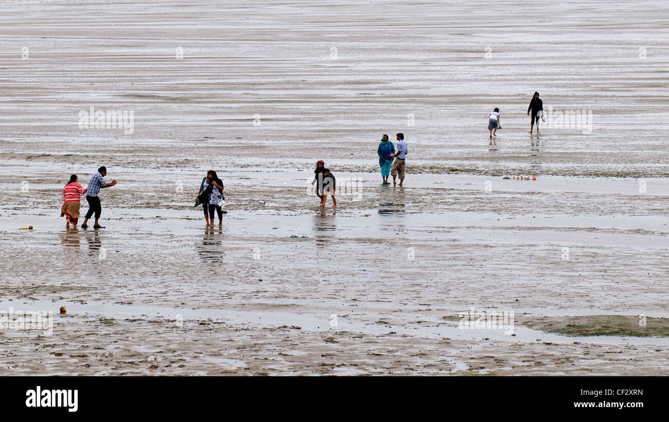 People walking on the foreshore of the Thames Estuary. Stock Photo