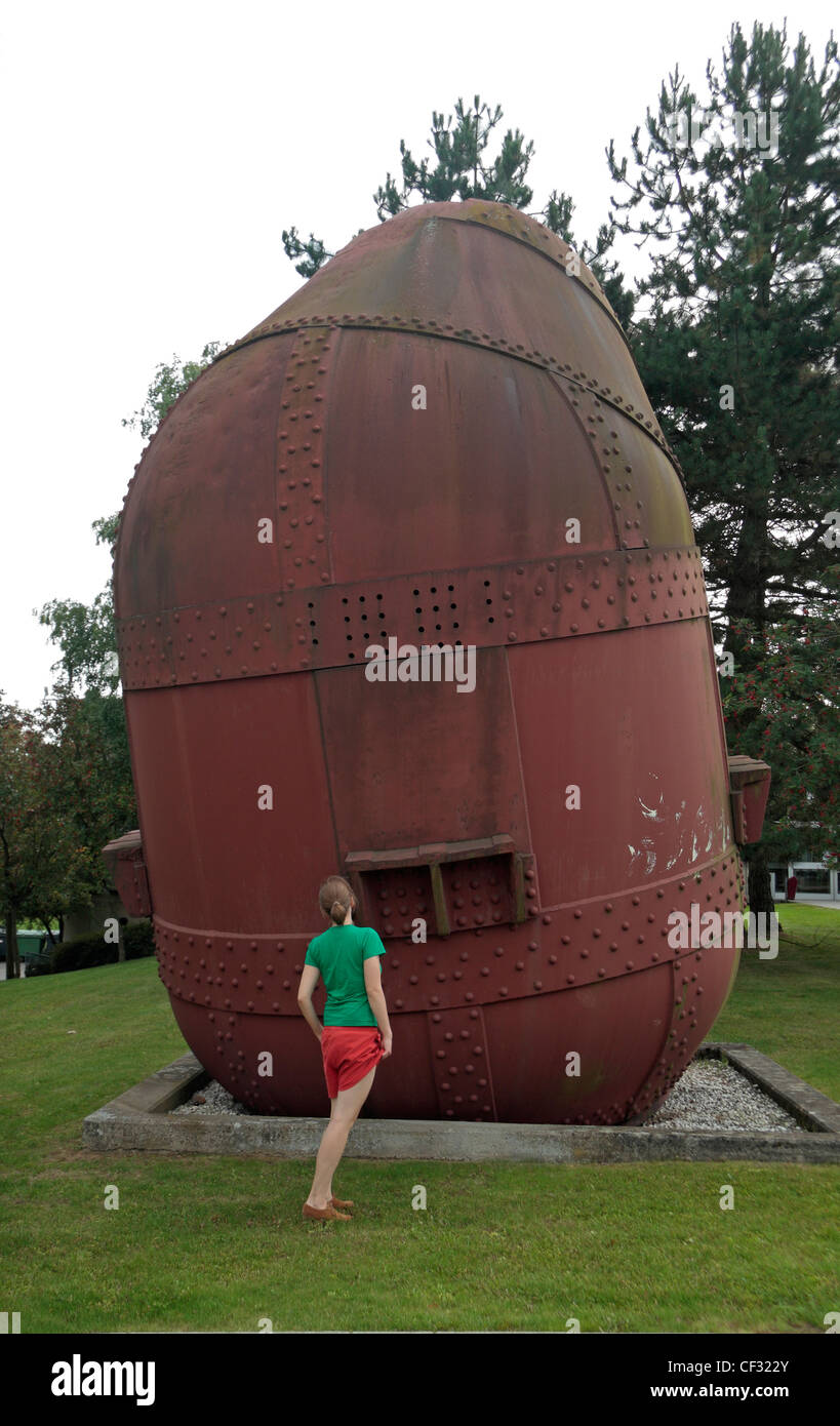 Young woman standing in front of an unusual sculpture on the Luxembourg University campus, Luxembourg. Stock Photo