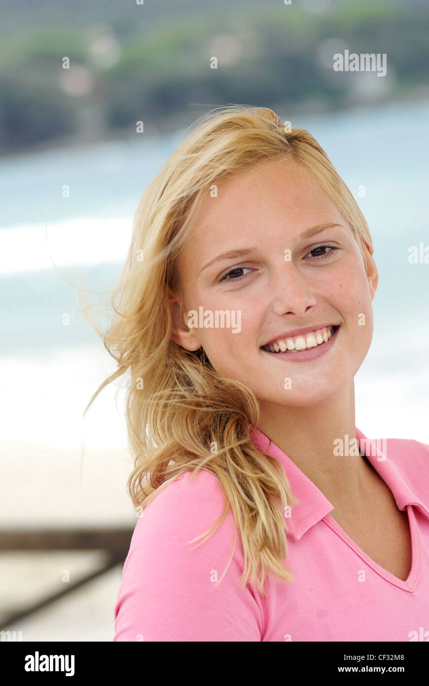 Female With Long Blonde Hair Wearing A Pink Top And Natural Make