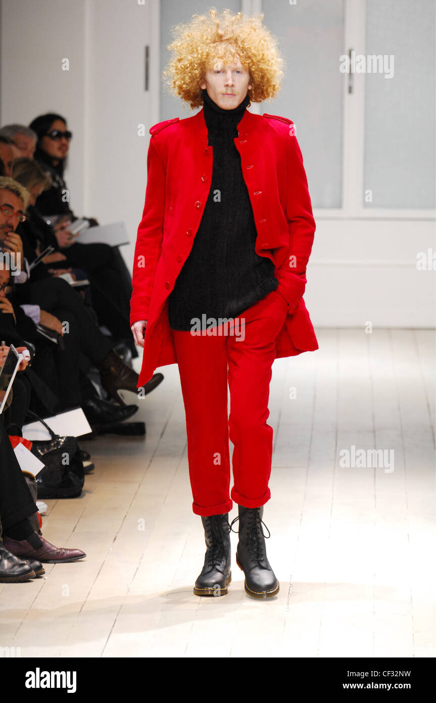 Yohji Yamamoto Menswear Paris Ready to Wear Red casual suit: Model curly blonde hair wearing black poloneck under bright red Stock Photo
