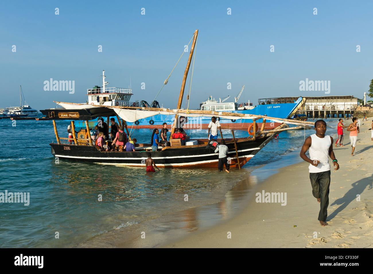 Tourists going on a boat trip Stone Town Zanzibar Tanzania Stock Photo