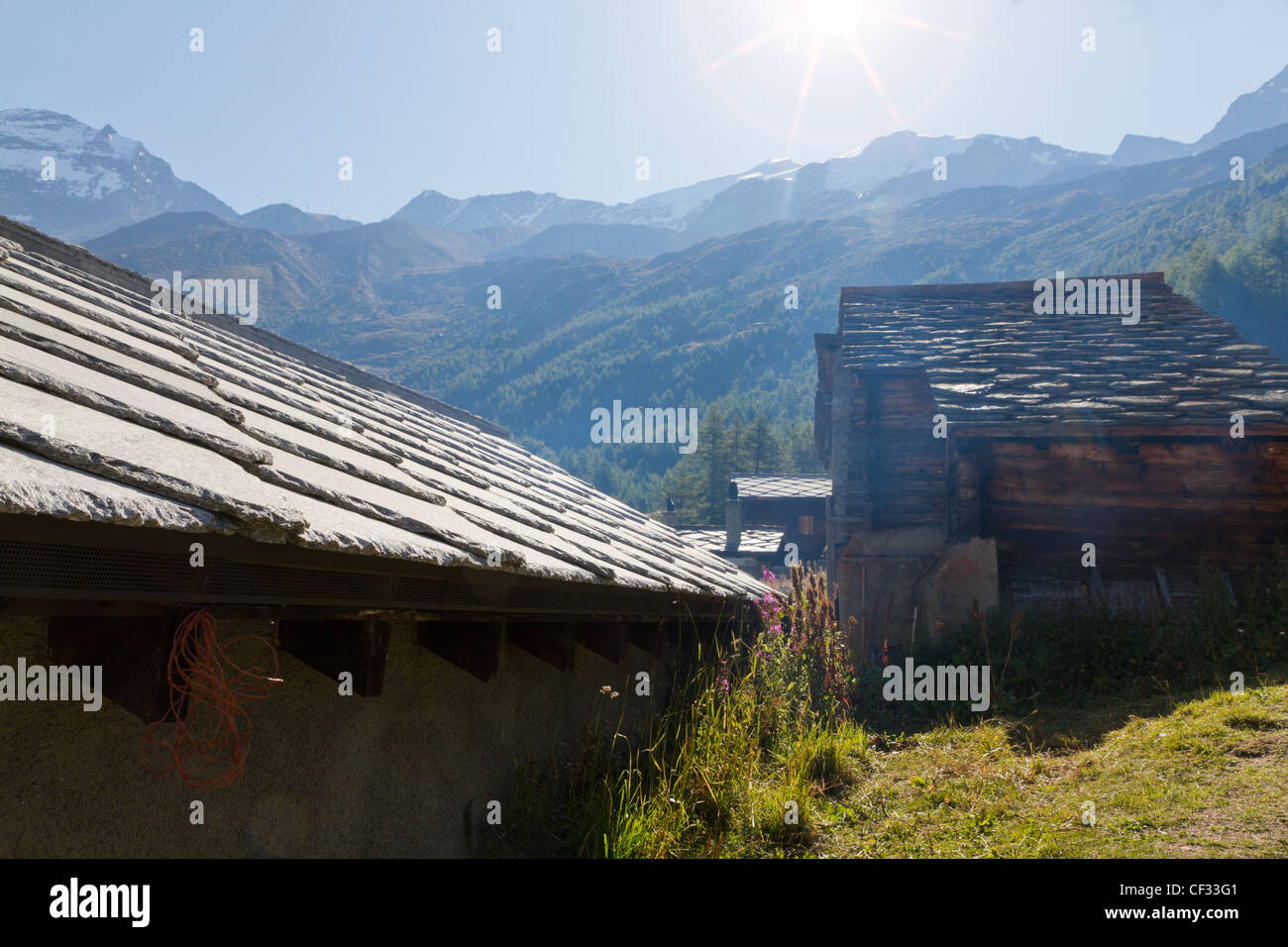 summer sun burning down on vintage blockhouses settlement with slate roofs in alpine Saas valley, Valais. Switzerland Stock Photo