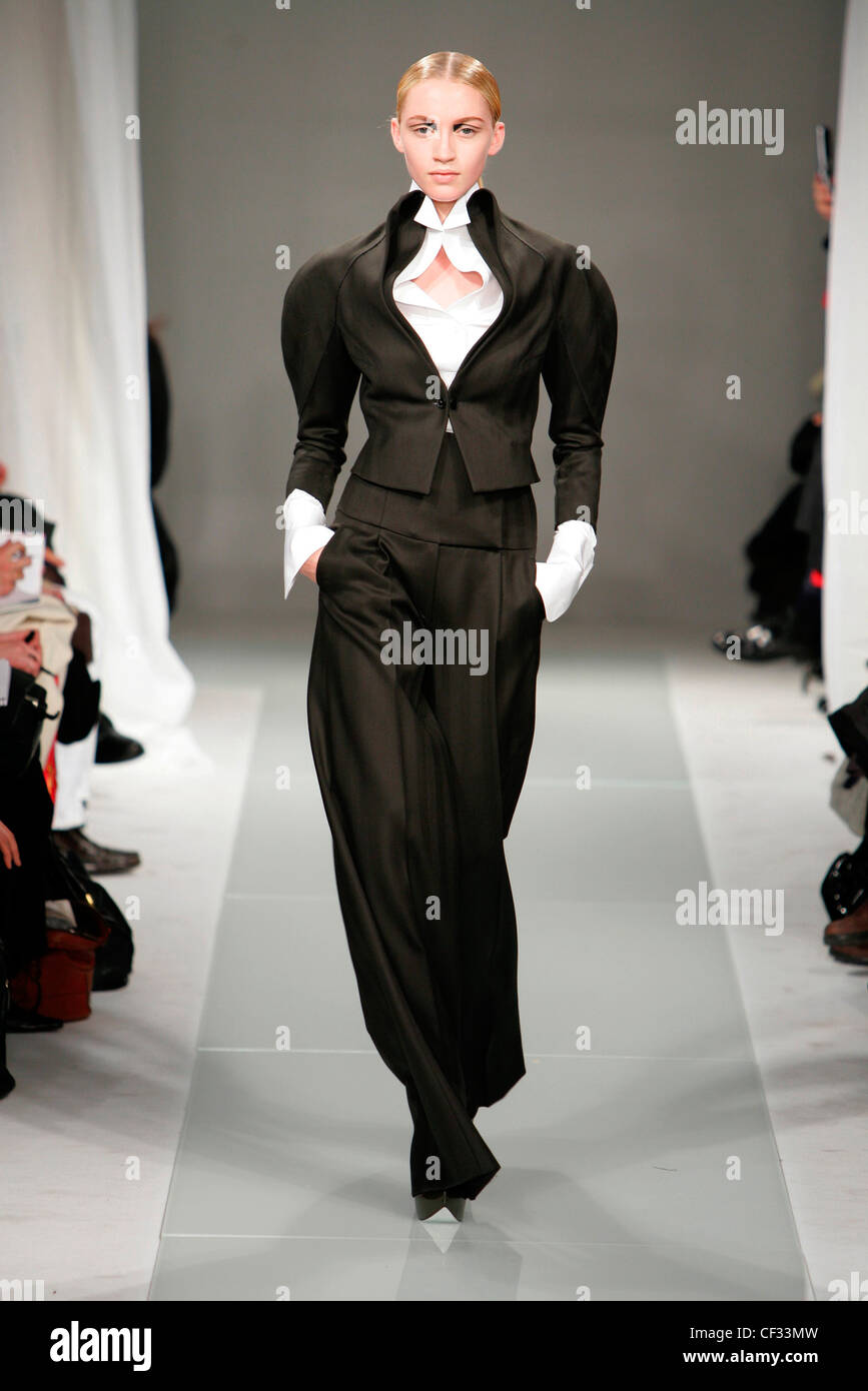 Brioni Milan Fashion Week Autumn Winter Model wearing black trouser suit, wide leg trousers, cropped jacket puff sleeves, Stock Photo