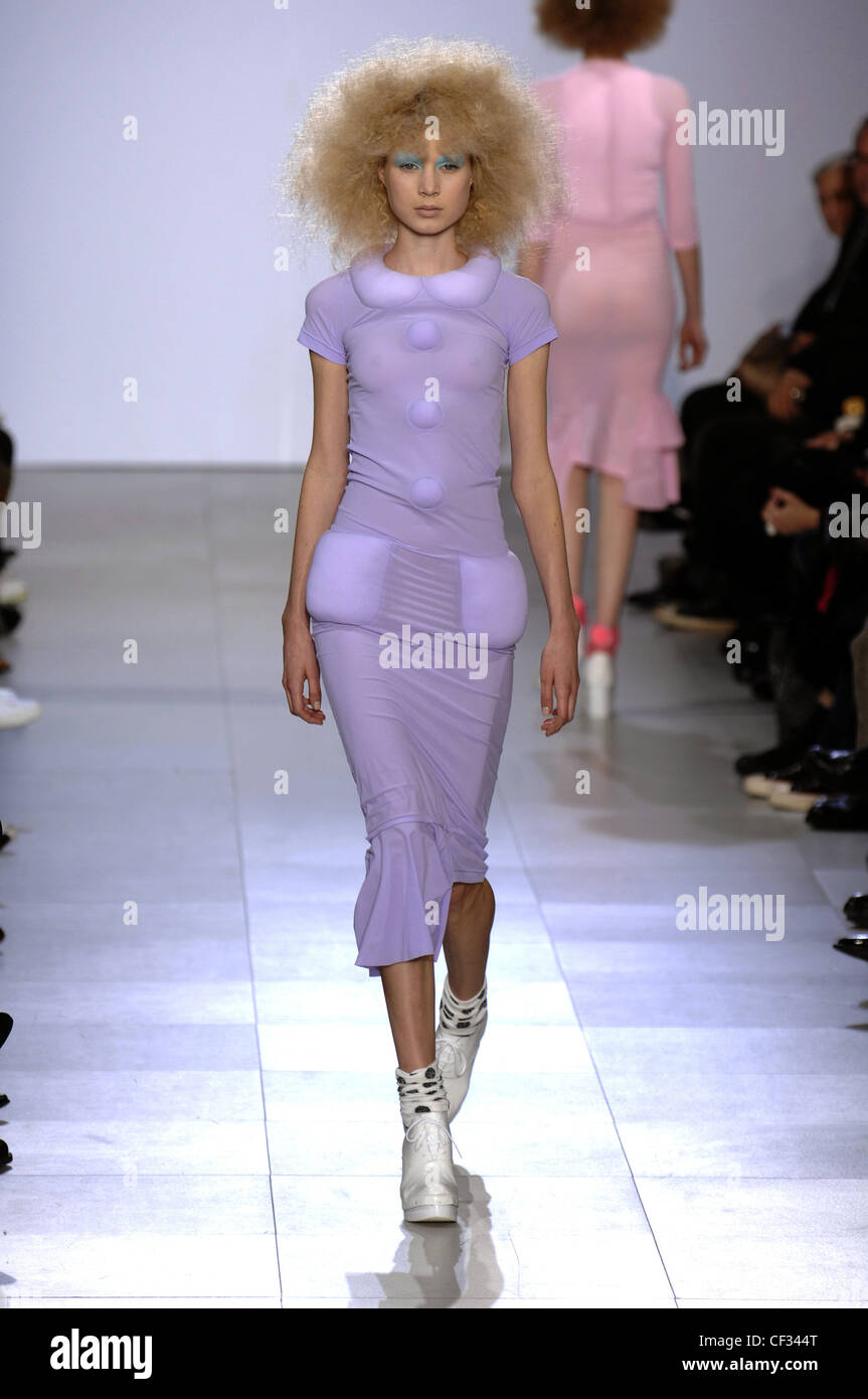 Comme Des Garcons Paris Ready to Wear Autumn Winter Model wearing mauve stretch dress raised padded collar pocket and button Stock Photo Alamy