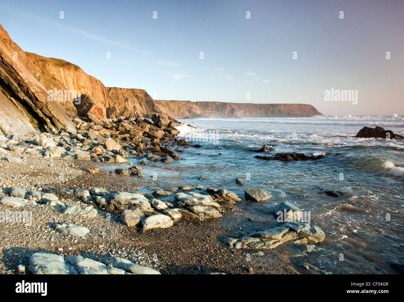 View of Irish sea with distant Hoopers Point, rock strewn coastline at Marloes Sands Pembrokeshire (National Trust) Wales UK Stock Photo