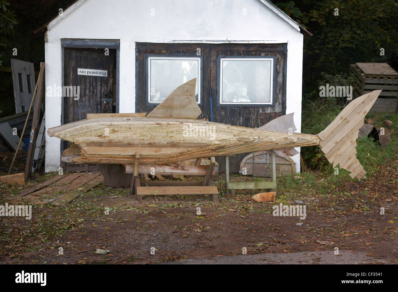 A wooden shark sculpture outside a workshop in Corrie on the Isle of Arran. Stock Photo