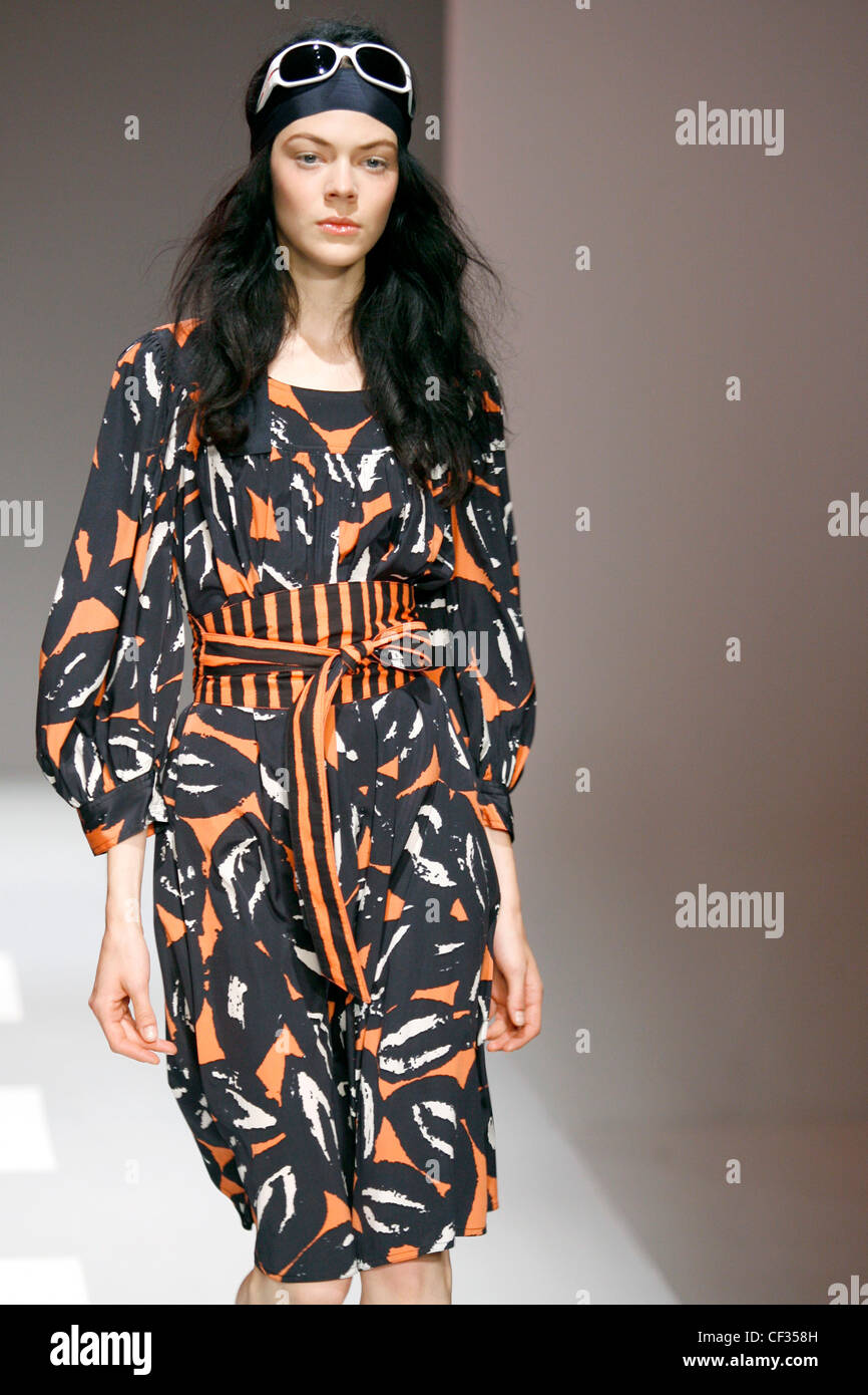 DKNY New York Ready to Wear Spring Summer Waisted black and orange print kaftan dress, with striped waist Stock Photo